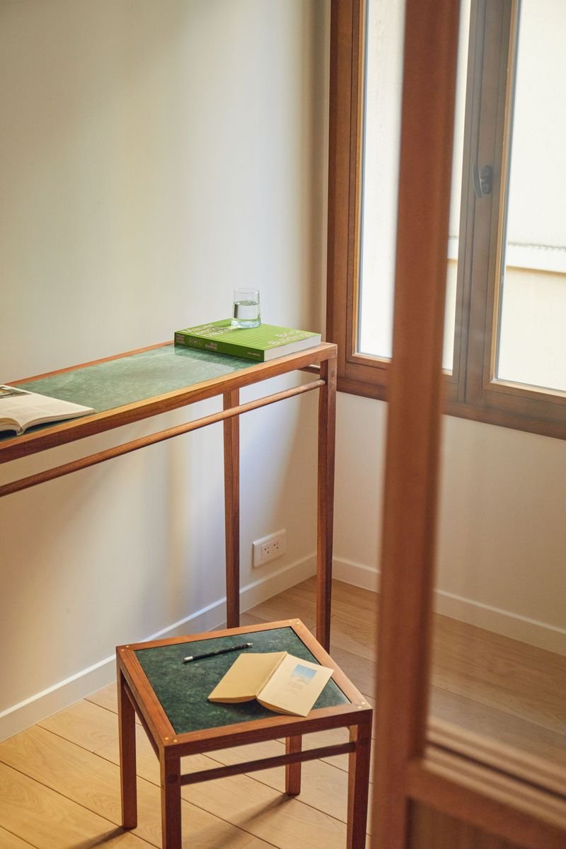 Bureau en bois devant la fenêtre, derrière la porte coulissante vitrée