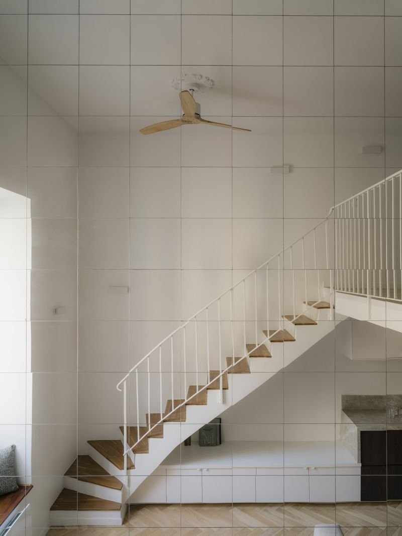 Escalier blanc aux marches en bois menant à la mezzanine