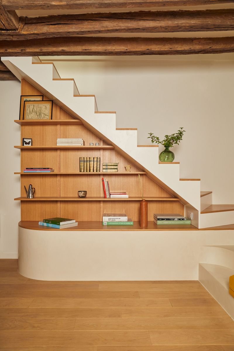 Bibliothèque en chêne sur mesure sous l’escalier blanc du séjour