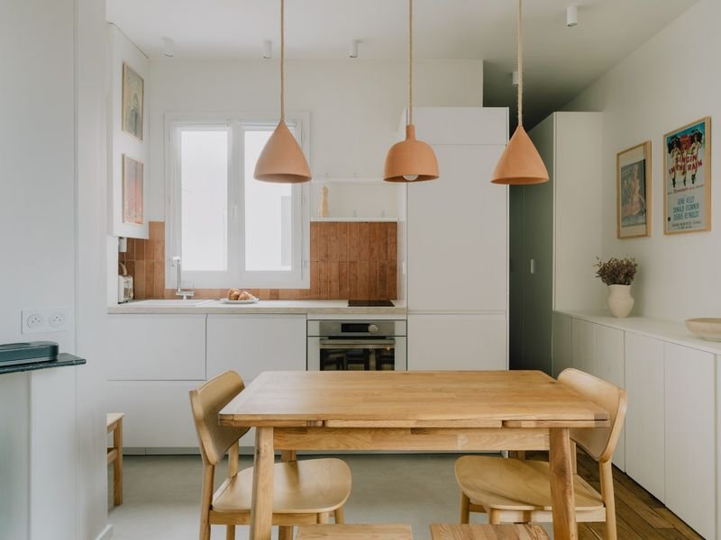 Cuisine ouverte et coin repas, suspensions en terre cuite au-dessus de la table en bois