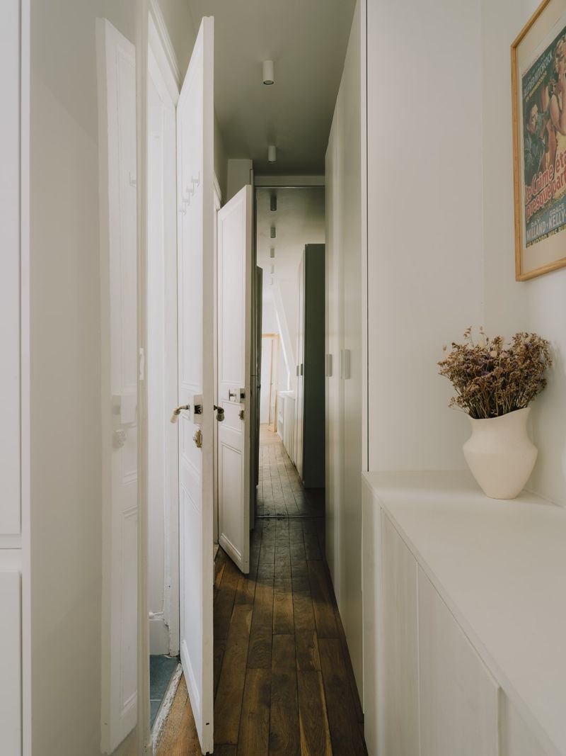 Couloir d’entrée bordé de placards blancs, parquet ancien restauré