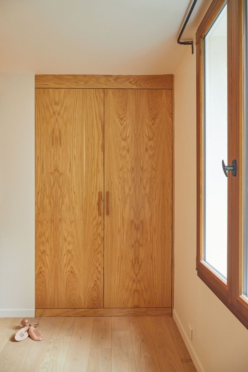 Chambre sous les combles : placard en chêne sur mesure près de la fenêtre