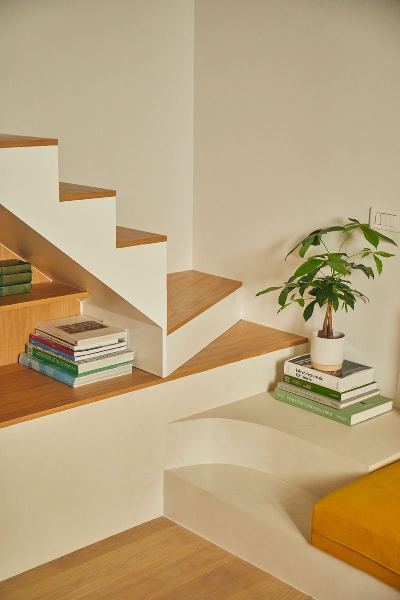 Escalier blanc aux marches en chêne, prolongé par une banquette arrondie