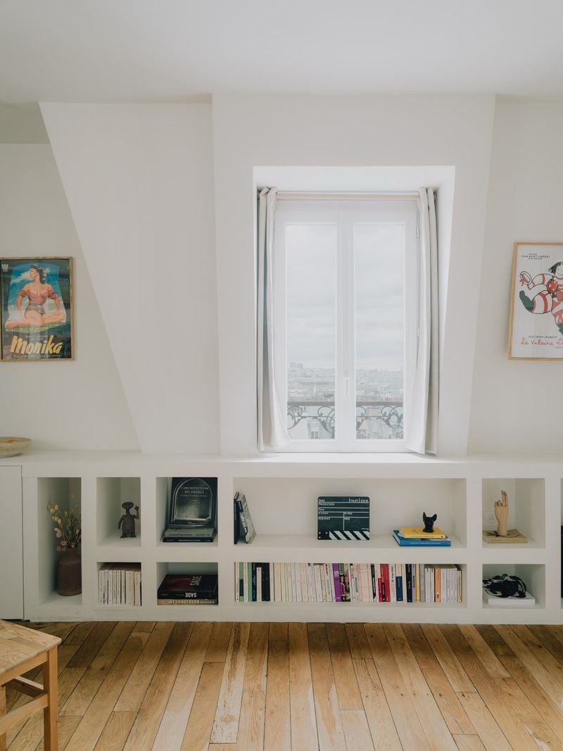 Bibliothèque basse sur mesure sous une fenêtre mansardée